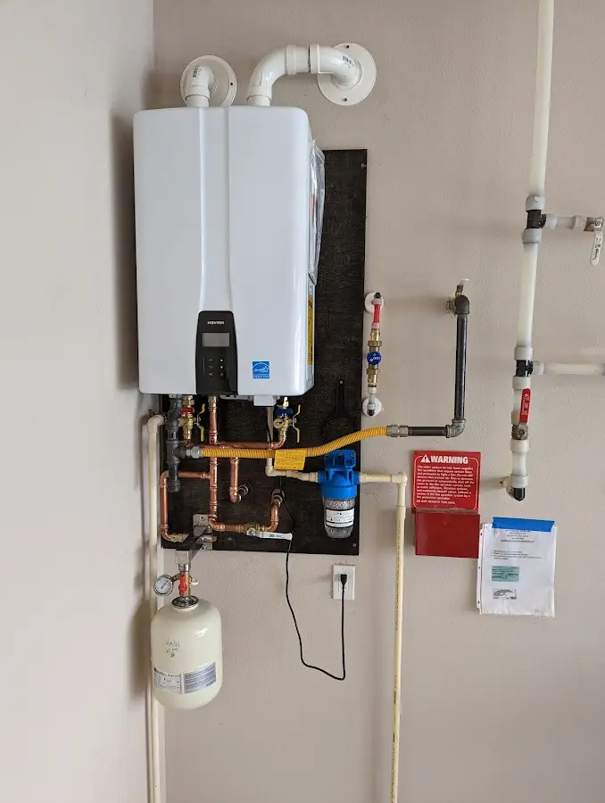 Professional plumber installing copper piping in a Stratham home